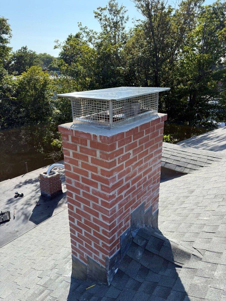 Restored masonry chimney and crown with stainless cap on a Dedham, MA home