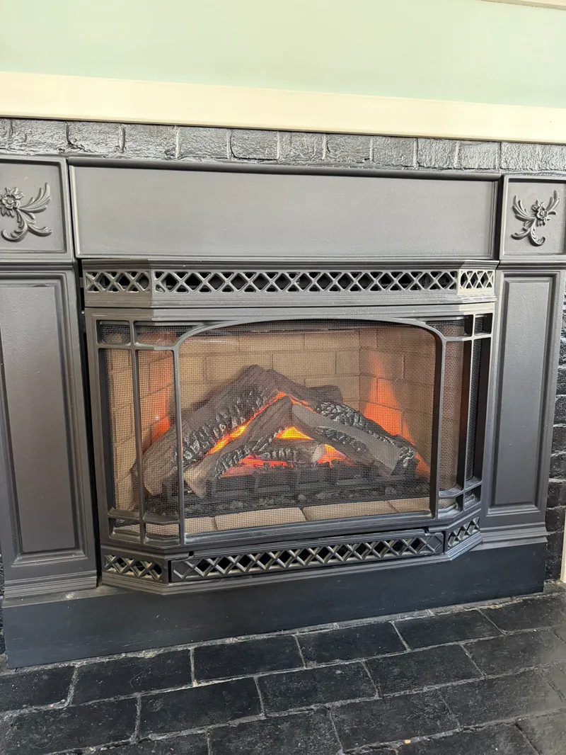 Gas fireplace insert with glowing gas logs — gas fireplace service example