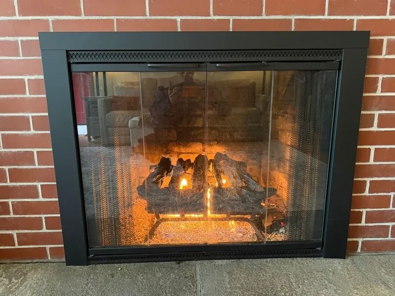 Gas logs with flames and a glowing ember bed — gas fireplace service example
