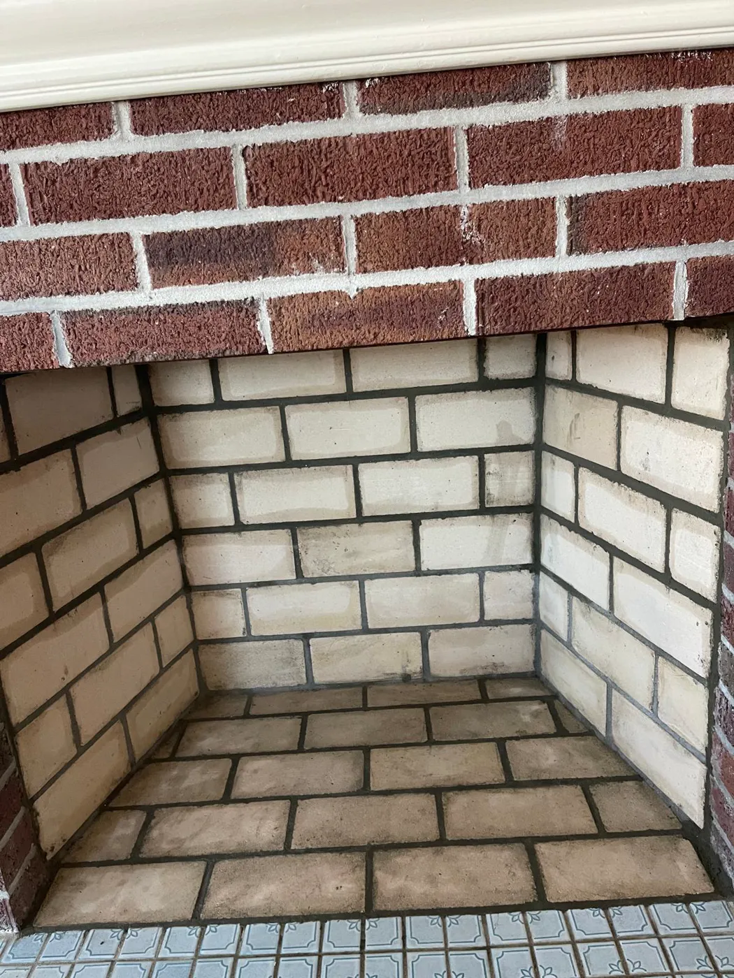 Firebox rebuilt with fresh tan firebrick inside a red brick fireplace