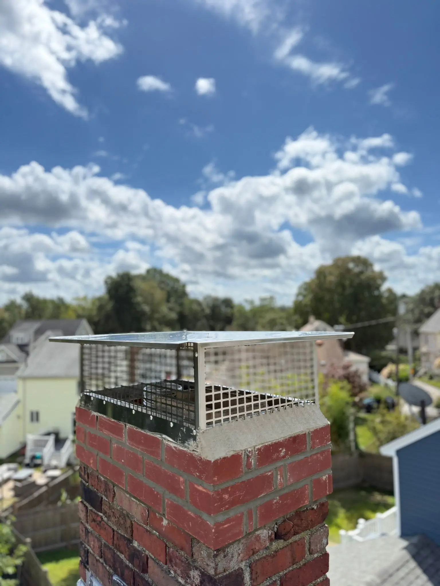 Stainless steel chimney cap installed on a brick chimney in Quincy