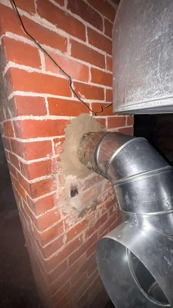 Stainless chimney liner connection at a brick wall thimble in Quincy MA