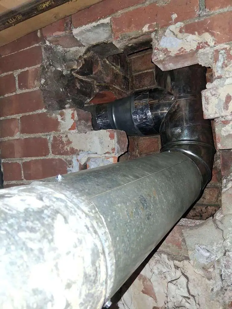 Chimney liner tied into the appliance vent through a damaged brick wall
