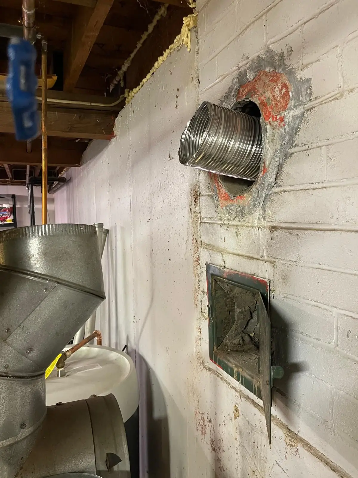 Stainless chimney liner pass-through on a basement wall in Quincy
