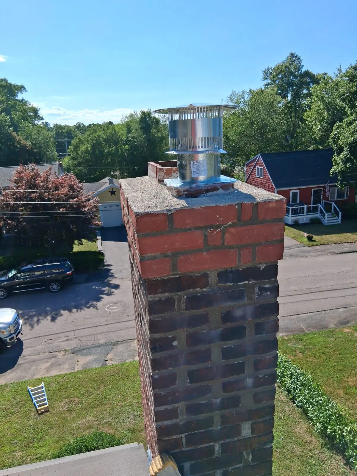Finished chimney liner installation with new stainless cap on a brick chimney in Quincy