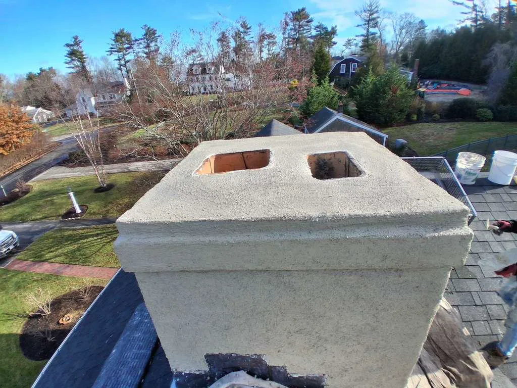Resurfaced chimney with a freshly parged crown, viewed from above